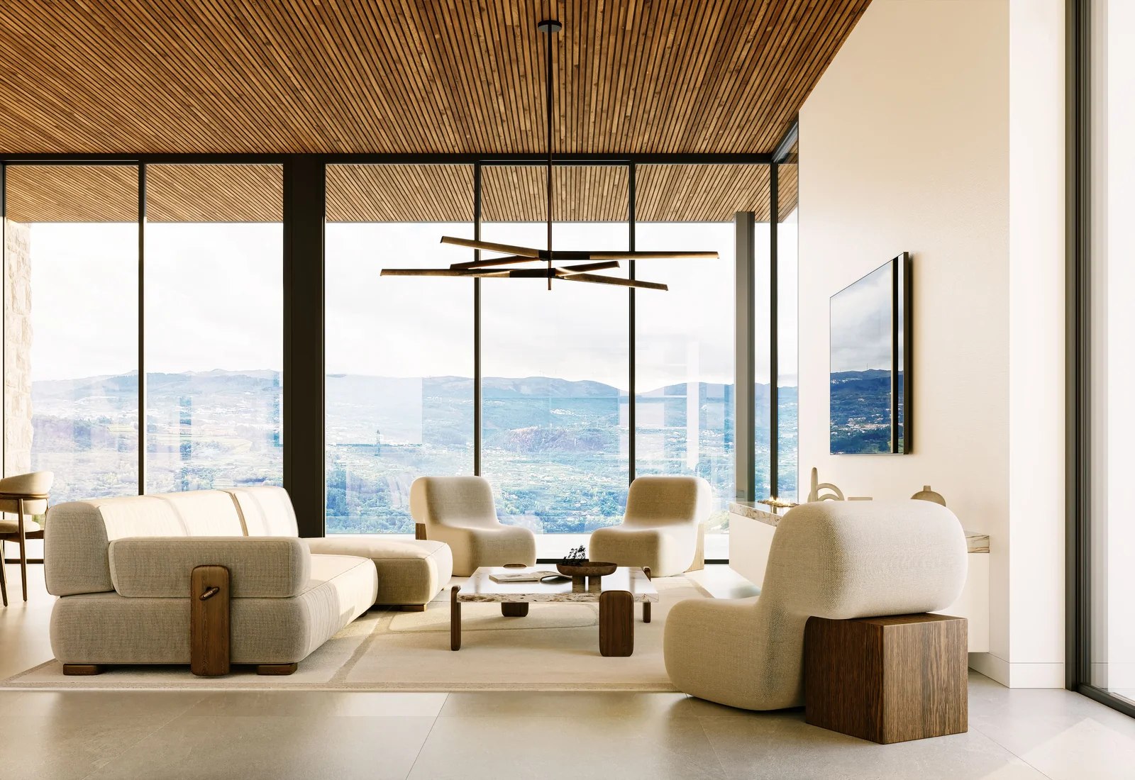 A sala de estar: assentos claros sobre pavimento de pedra, tecto em ripado de madeira a correr toda a profundidade da sala, um candeeiro escultórico preto, e envidraçados em dois lados a abrir para o vale.