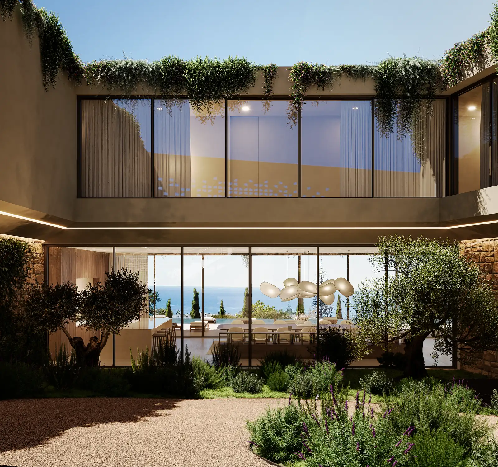 Um pátio de entrada rasgado no volume, paredes forradas a madeira vertical, um parapeito plantado em consola por cima, e o mar visível através da casa do lado oposto.