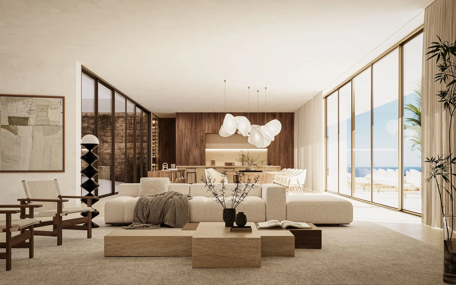 A sala de estar: assentos baixos e claros em torno de uma mesa de pedra, uma parede forrada a madeira de um lado, envidraçados de correr em dois lados e o mar ao fundo da sala.