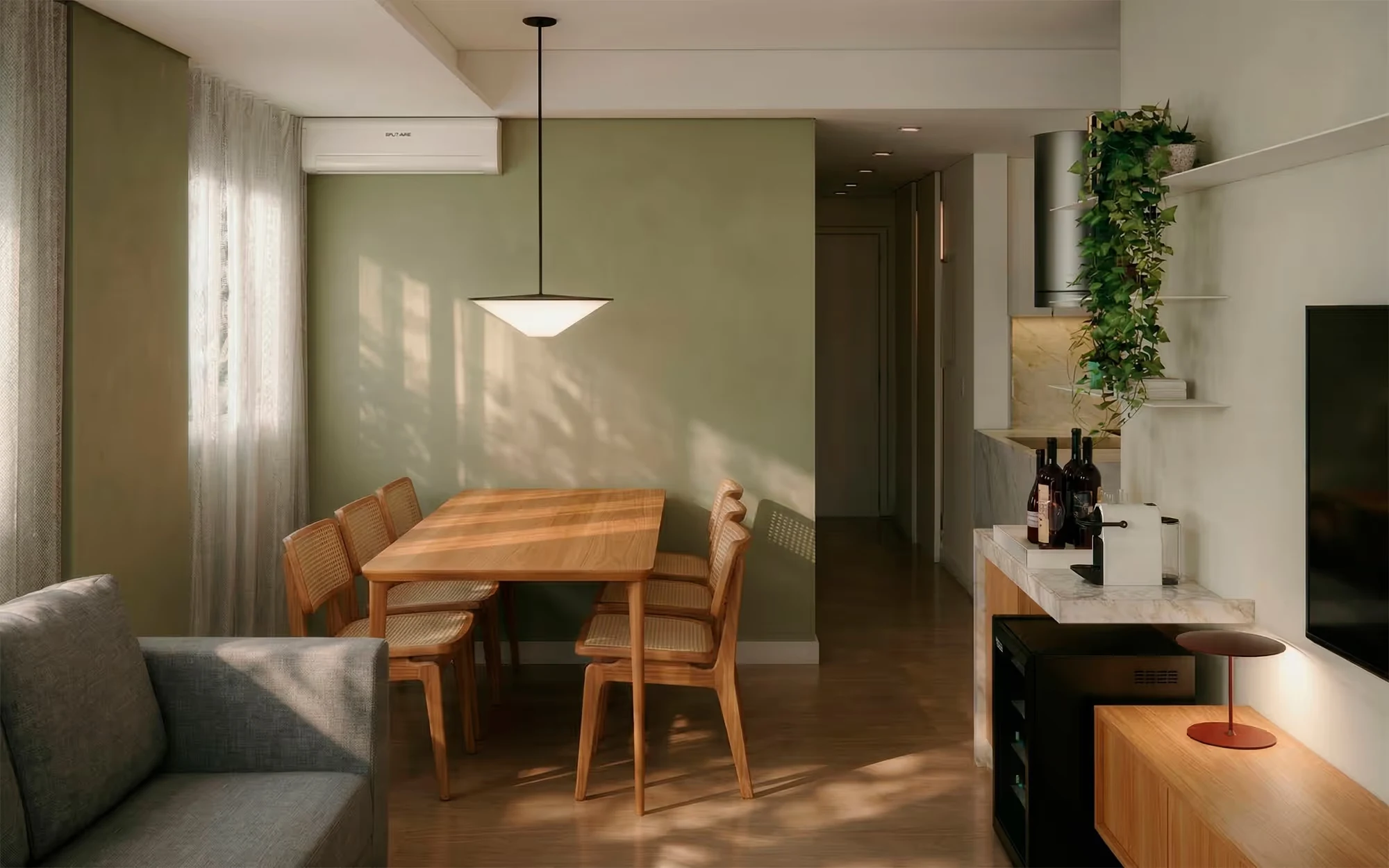 Área de jantar com mesa de madeira e cadeiras de palhinha sob um pendente cônico, parede verde-sálvia com luz filtrada e um sofá cinza em primeiro plano., Apartamento Botaní, Pompéia, São Paulo